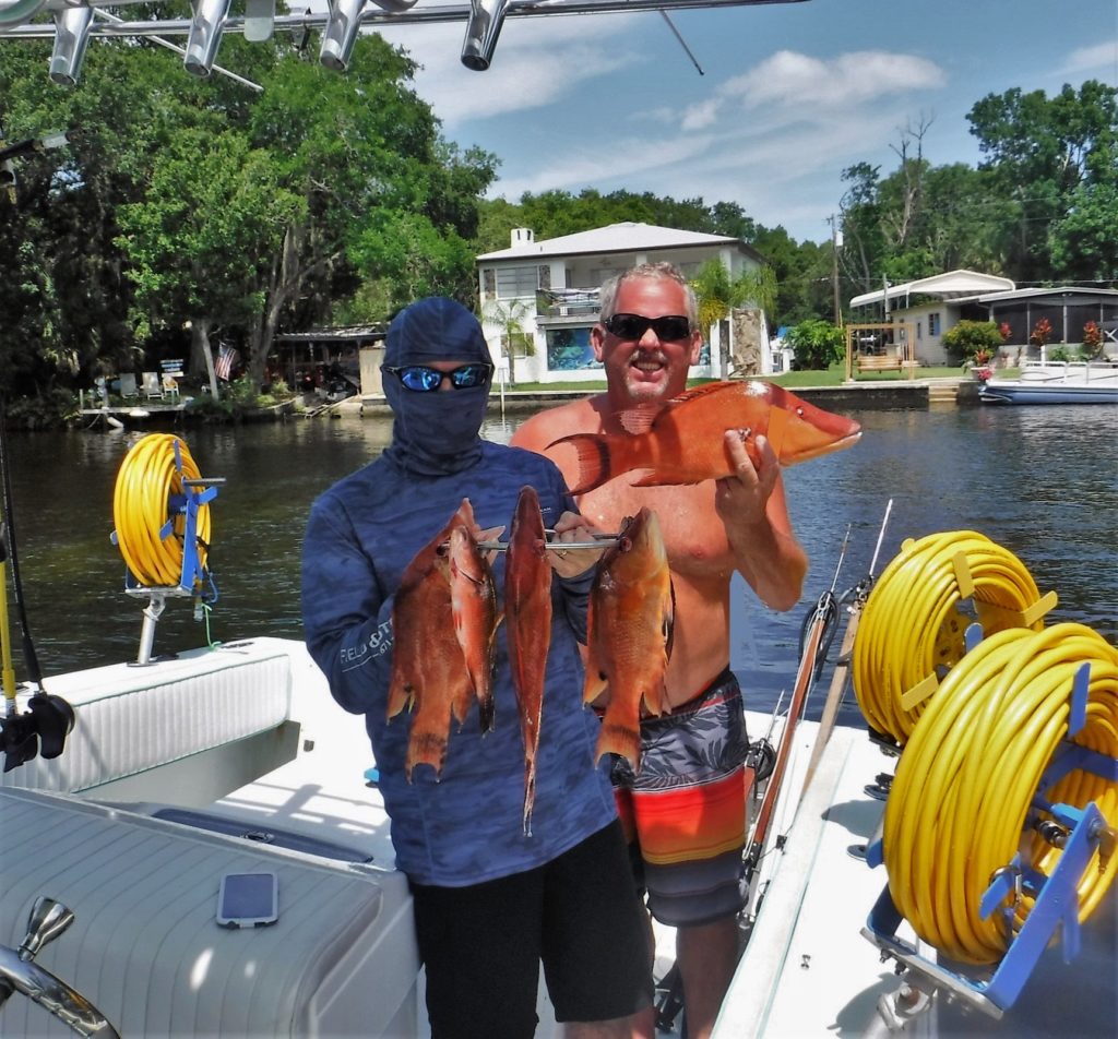 Two men on a boat posing with their catch using Gator Gill LLC lobster harvesting equipment in Florida.